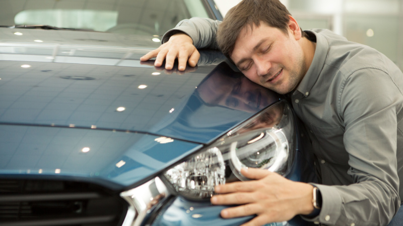 Uomo che abbraccia auto nuova
